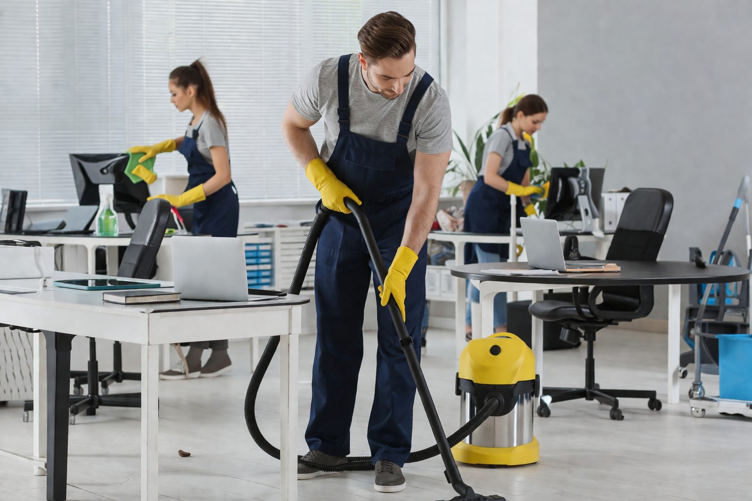 Équipe de nettoyage en train d’entretenir des bureaux modernes pour garantir un environnement de travail propre et professionnel
