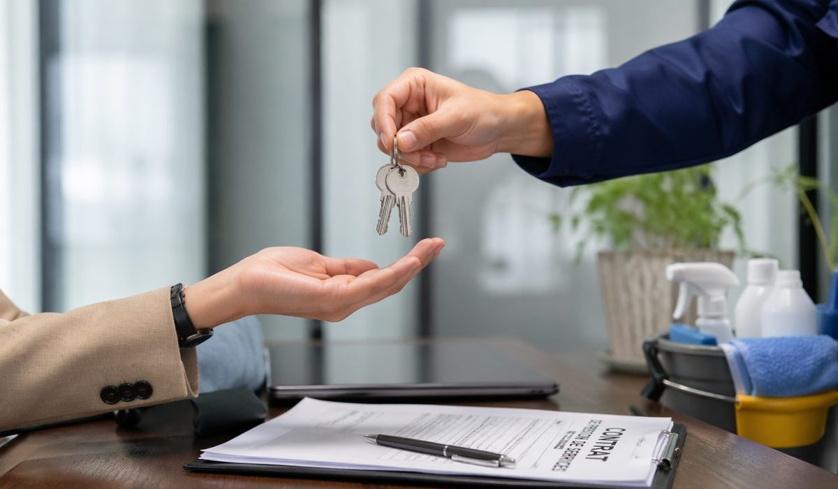 Remise de clés entre un responsable d’entreprise et un prestataire de nettoyage de bureaux dans un environnement professionnel