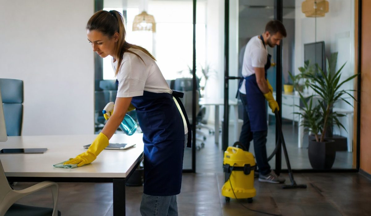 Agent d’entretien nettoyant un bureau moderne avant une journée portes ouvertes dans une entreprise