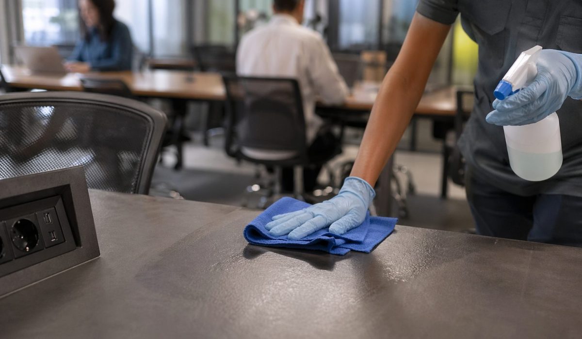 Désinfection de bureaux dans un coworking très fréquenté avec nettoyage professionnel des postes de travail et des surfaces partagées